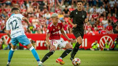 Alan Godoy controla un balón ante la atenta mirada de Eder Mallo, durante el Nàstic-Málaga. Foto: Nàstic