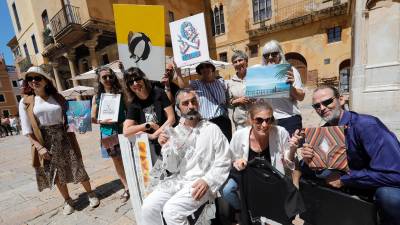 Los y las artistas de la primera Walking Gallery en el Pla de la Seu con sus obras. FOTO: P. FERRÉ