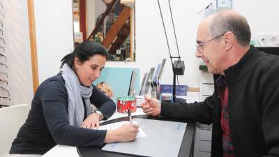 Una vecina, firmando el documento que reclama un mejor servicio sanitario. FOTO: Alba Mariné