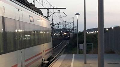 El tren Altaria al fondo y otro convoy parado en la estación de Cunit.