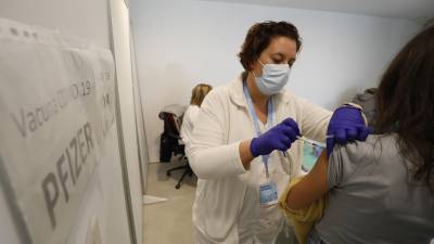 Una enfermera vacuna en el Palau d’Esports de Campclar, ayer. Foto: Pere Ferré