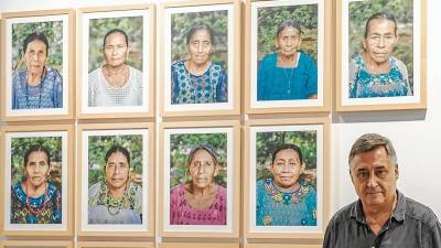 Gervasio Sánchez junto a algunos de los retratos de las mujeres que fueron violadas en grupo en Guatemala. Foto: Fabián Acidres