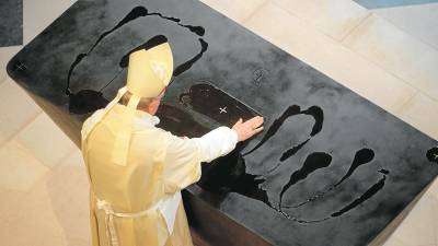 L’arquebisbe de París, Laurent Ulrich, espargint l’oli de Coselva sobre l’altar de la catedral de Notre-Dame amb les seves mans, diumenge. Foto: Efe