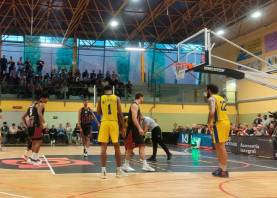 Niko Gosnell se prepara para lanzar un tiro libre durante el partido contra el Salou, mientras Joelvin Cabrera lo anima. Foto: Bisbal Bàsquet