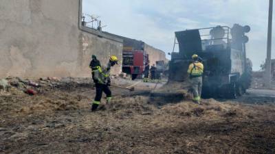 Un bombero apagando las llamas de la máquina agrícola de Forès. Foto: DT
