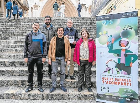 Los organizadores del ciclo ‘La ciutat a cau d’orella’ junto al cartel de esta edición. Foto: Joan Carles Borrachero/Cedida