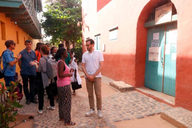 Jordi Cuadras i Amy Sabaly, amb altres membres de la missió institucional, davant la Casa dels Esclaus de l’illa de Gorée. Foto: ACN