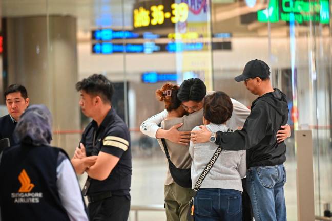 Pasajeros se abrazan con familiares después de la tragedia. Foto: EFE