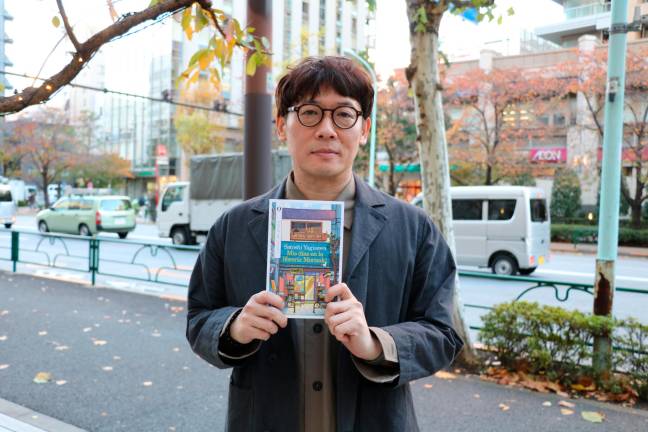 El autor nipón Satoshi Yagisawa posa con su libro ‘Mis días en la librería Morisaki’. FOTO: EFE/ Sara Rodríguez Pachón