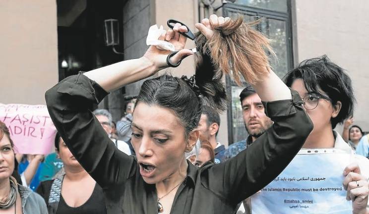 $!Nasibe Samsaei, una iraní residente en Turquía, se corta la coleta durante una protesta frente al consulado iraní en Estambul. Foto: Yasin Akgul