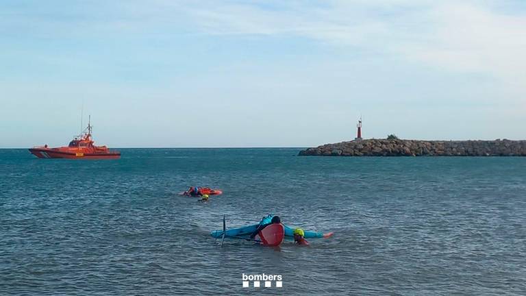 Los dos rescatadores remolcando la tabla y la vela y a la víctima hasta la orilla. Foto: Bombers