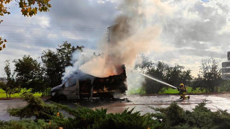 Un bombero intenta apagar las llamas del camión. Foto: I.Alcalà