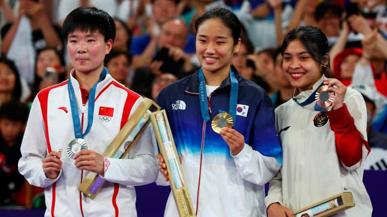 La china Bing Jiao He, a la izquierda, con el pin de España en homenaje a Marín. Foto: EFE