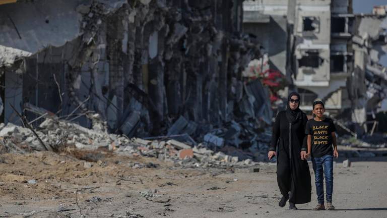 Imagen de dos personas paseando por una de las zonas destruidas en Gaza tras los Bombardeos. Foto: EFE
