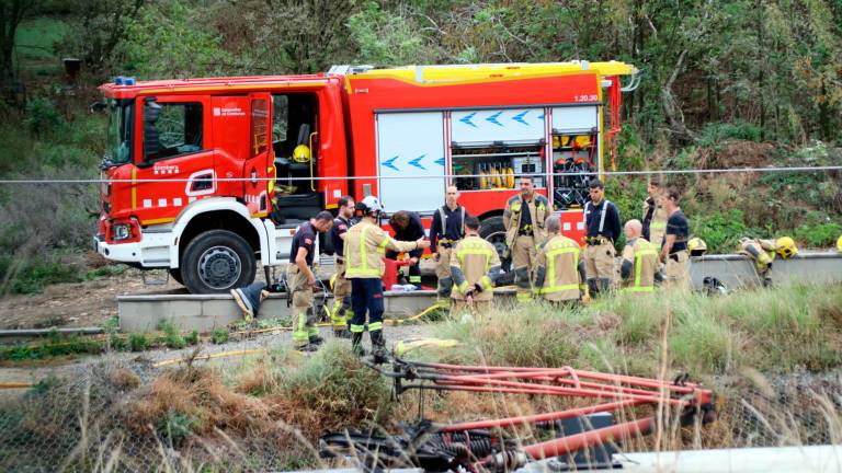 Vista del agujero que ha causado el incendio de la catenaria en el tramo de la R3. Al fondo, los bomberos. Foto: ACN