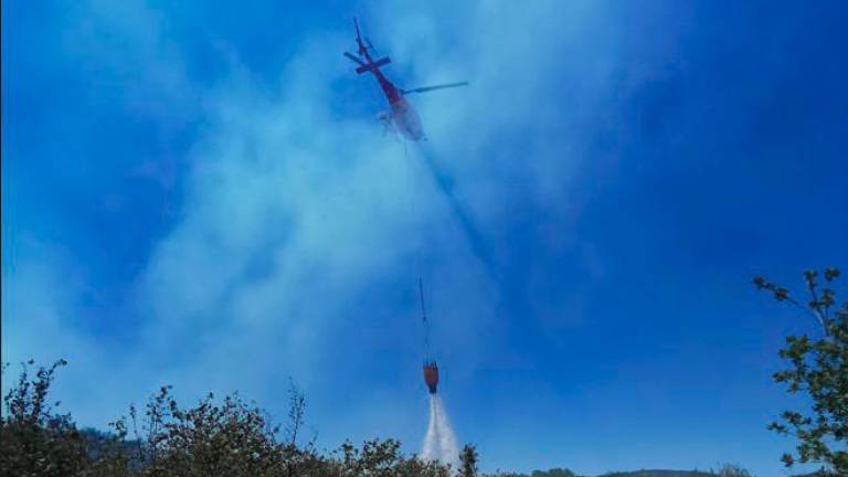 En la extinción participa también un helicóptero bombardero. Foto: Àngel Juanpere