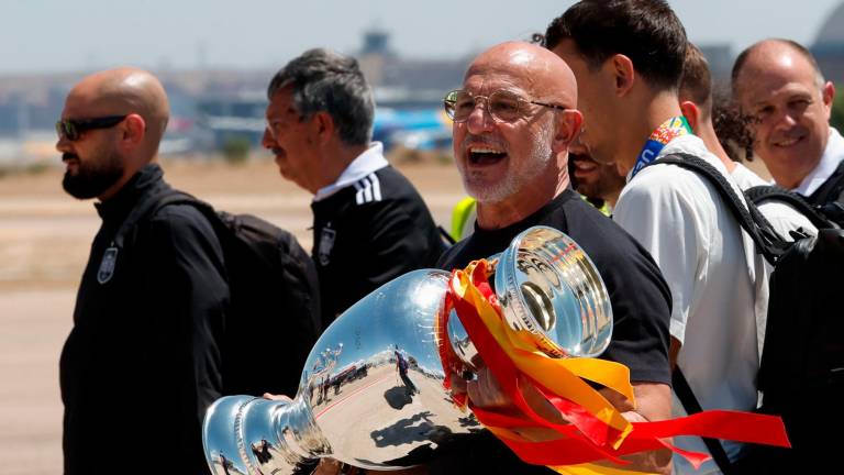 Luis de la Fuente sostiene la copa de la Eurocopa en su llegada al aeropuerto de Barajas. Foto: EFE