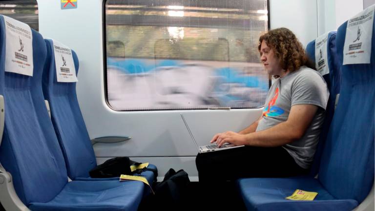 Un usuario de Rodalies trabajando dentro del tren. Foto: ACN