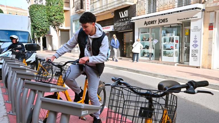 Un jove agafant una bici Ganxeta dels ancoratges del Raval de Jesús, ahir. Foto: Alfredo González