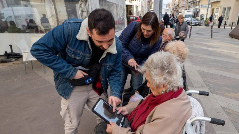 Personal de l’Ajuntament, facilitant la votació dels veïns amb tauletes. FOTO: Joan Revillas