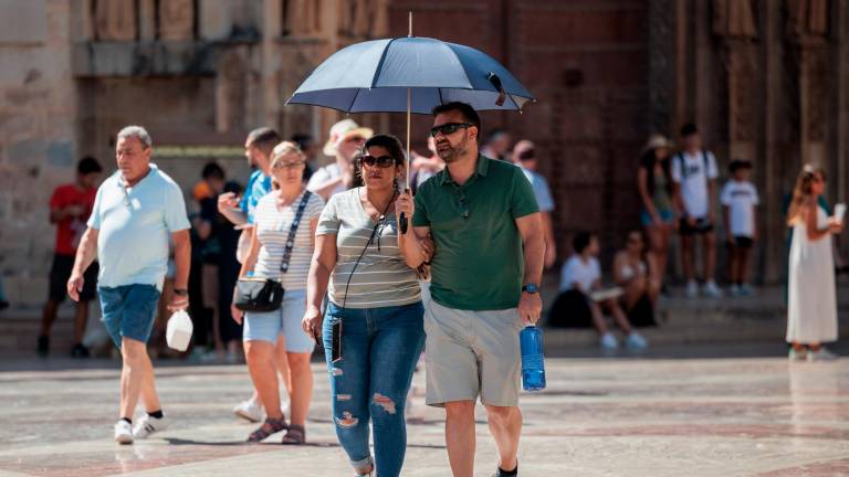 Una pareja se protege del calor con un paraguas hace unos días en Toledo. foto: biel aliño/efe