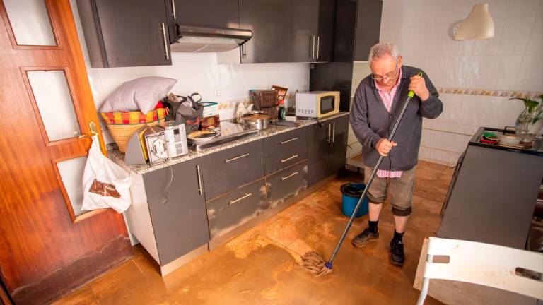 Un hombre limpiando la cocina de su chalet en La Móra. Foto: Marc Bosch