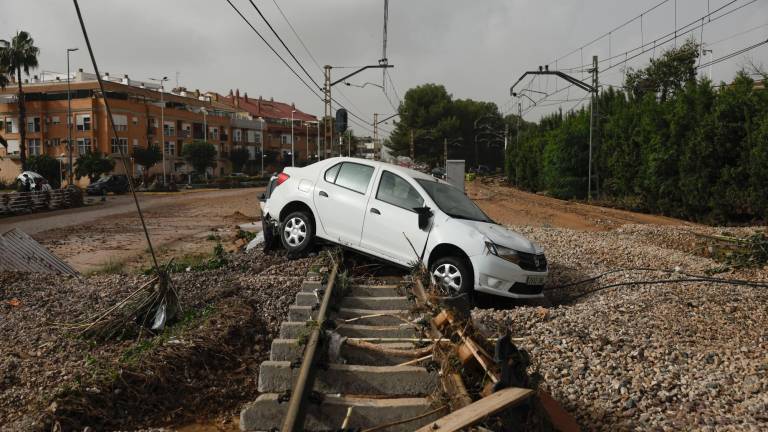 Un cohe encima de una vía de tren. Foto: EFE