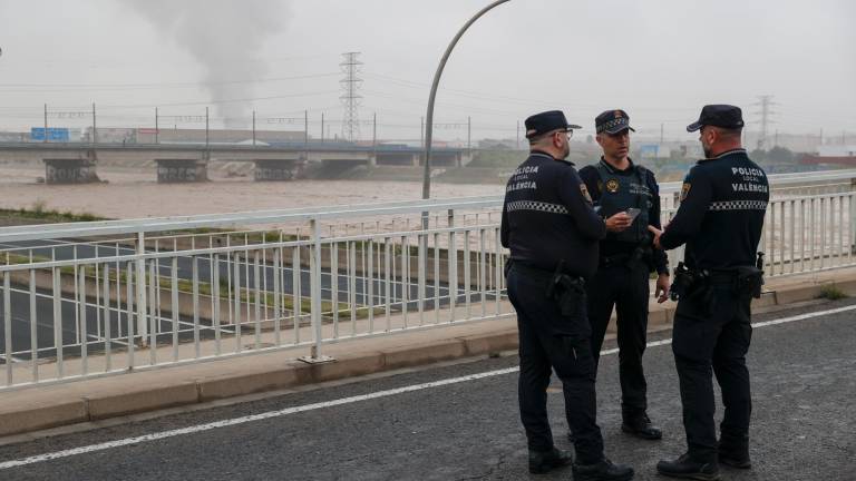 Agentes de la Policía Local mantienen cortado el puente de acceso sobre el nuevo cauce del Turia al barrio de La Torre de Valencia, uno de los barrios periféricos de la zona sur que sufre inundaciones a causa de las fuertes lluvias de las últimas horas. Foto: EFE