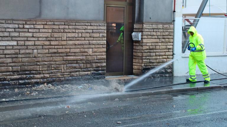 Un operario limpia la suciedad que ha atascado las alcantarillas de la calle Reial de Tarragona. Foto: ACN