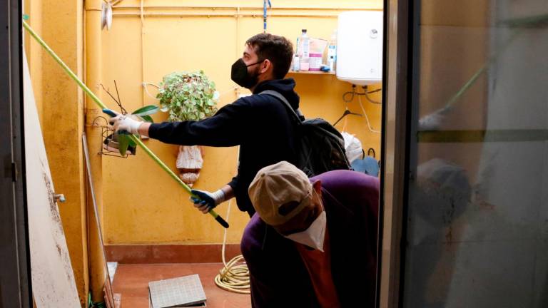 Un joven universitario ayuda a limpiar la casa de un amigo en Aldaia. Foto: ACN