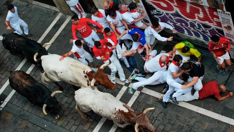 Los toros de la ganadería de Fuente Ymbro a su paso por la calle de la Estafeta en el cuarto encierro de los Sanfermines este miércoles en Pamplona. Foto: EFE