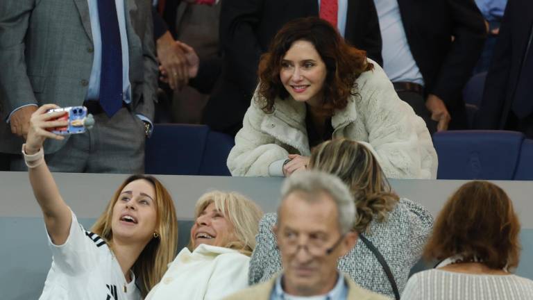 La presidenta de la Comunidad de Madrid, Isabel Díaz Ayuso (c), se hace fotografías con aficionadas este sábado, durante el partido de la jornada 11 de LaLiga EA Sports, entre el Real Madrid y el FC Barcelona, en el estadio Santiago Bernabéu de Madrid. EFE/ Juanjo Martín