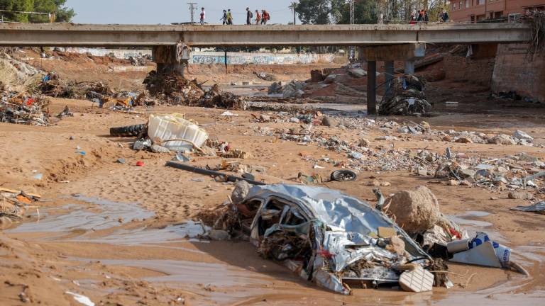 Restos de vehículos arrastrados por la corriente en el barranco del Poyo en Paiporta, Valencia, este lunes. Foto: EFE