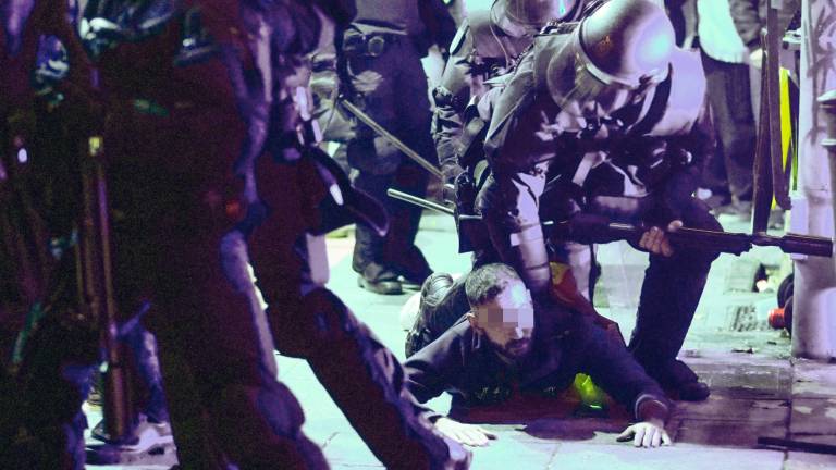 Un policía ayuda a un compañero a levantarse durante los disturbios tras la concentración contra la Amnistía, este miércoles en la madrileña calle Ferraz, junto a la sede central del PSOE. Foto: EFE/ Borja Sanchez-Trillo