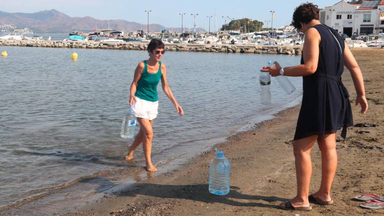 Vecinos de Port de la Selva llenando garrafas en la playa. Foto: ACN