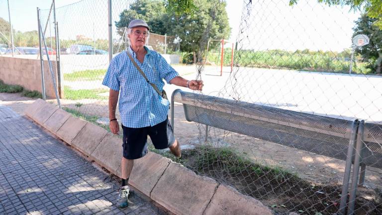 $!El presidente de la Associació de Veïns I de Maig, Eduardo Navas, en la pista deportiva, con la reja rota. FOTO: Alba Mariné