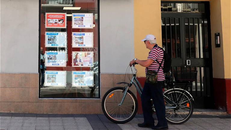 Un hombre mira las ofertas en el escaparate de una inmobiliaria. Foto: EFE