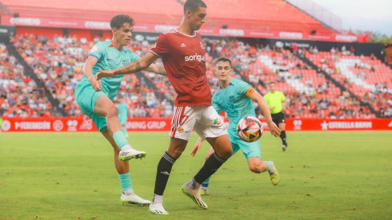 Pablo Fernández protege el cuero ante la presión de Héctor Fort y Marc Casadó. Foto: Àngel Ullate