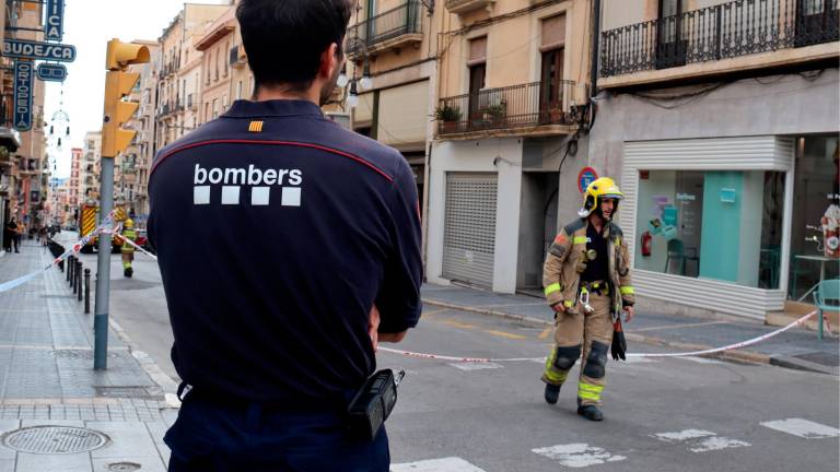 Dos agentes de los Bombers trabajando en un edificio con riesgo de derrumbamiento en la calle Unió de Tarragona. Foto: ACN