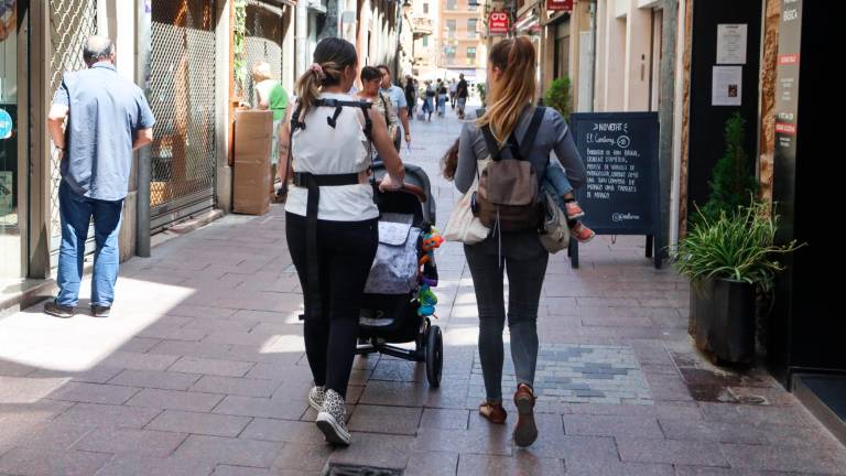 Dos mujeres empujando un coche de bebé por la céntrica calle Jesús. Foto: Alba Mariné