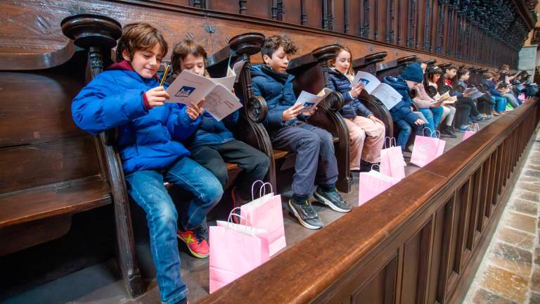 Los niños sentados en los sillares del coro de la catedral tarraconense. foto: Marc Bosch