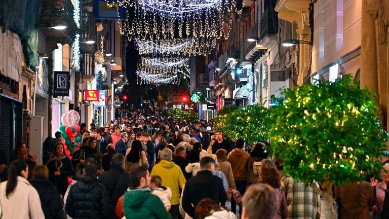 Desenes de persones caminen pel Carrer Llovera al Nadal de 2023. FOTO: Alfredo González