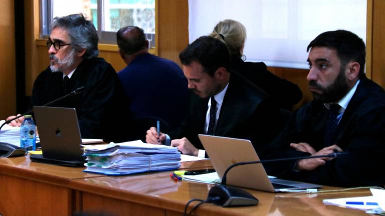 Abogados de la defensa y los principales acusados del caso, en segundo plano y de espaldas, al inicio del juicio oral por el caso del fraude en los exámenes del carnet de conducir vinculado a las autoescuelas Roquetes-Temple. Foto: ACN