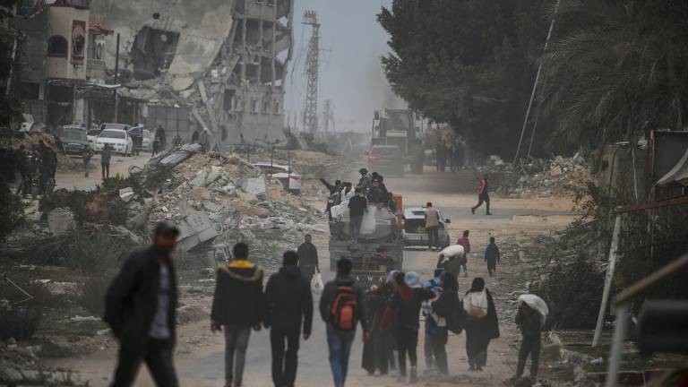 Palestinos caminan entre edificios destruidos en medio de un alto el fuego entre Israel y Hamás, en Rafah, al sur de la Franja de Gaza. Foto: EFE