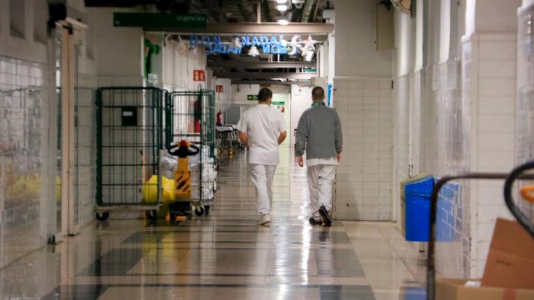 Dos sanitarios caminando por el pasadizo de un hospital. Foto: ACN