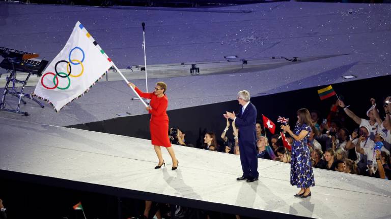 La alcaldesa de Los Angeles, Karen Bass (i), ondea la bandera olímpica, junto al presidente del COI, Thomas Bach. Foto: EFE