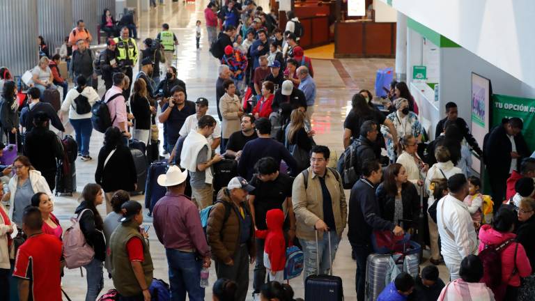 Viajeros hacen fila este viernes en el Aeropuerto Internacional de la Ciudad de México. Foto: EFE