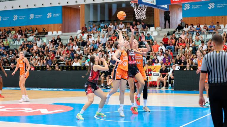 Las jugadoras de Valencia Bàsquet y Uni Girona pelean bajo el aro del Palau d’Esports de Catalunya. foto: alba mariné