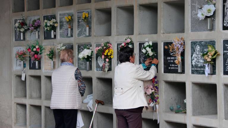 Dos señoras llevan flores en homenaje a sus difuntos en el cementerio de Montgat durante el día de Tots Sants. Foto: ACN