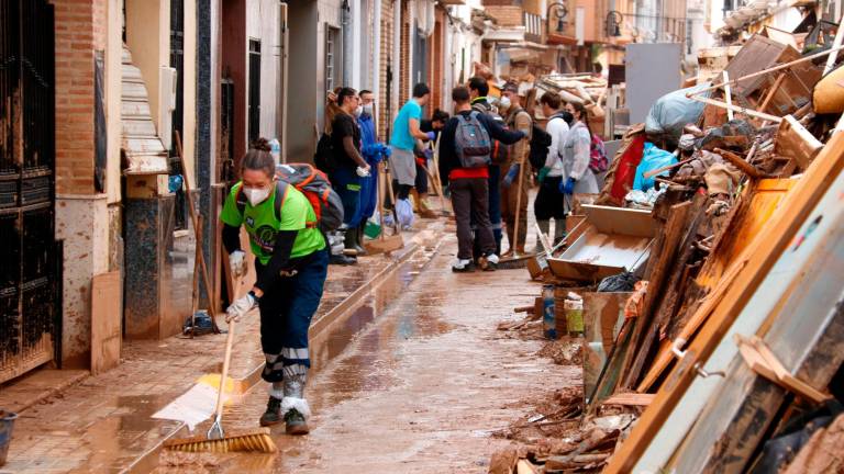 Varias personas ayudan a quitar barro en Aldaia. Foto: ACN